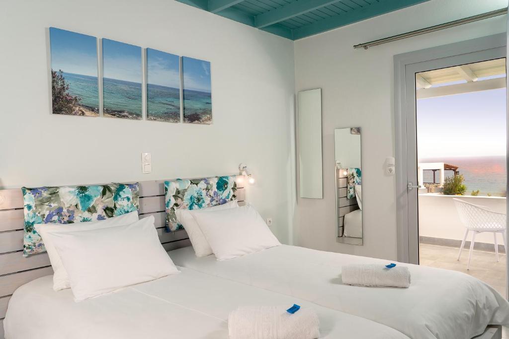 two beds in a bedroom with a view of the ocean at Paradisos in Frangokastello