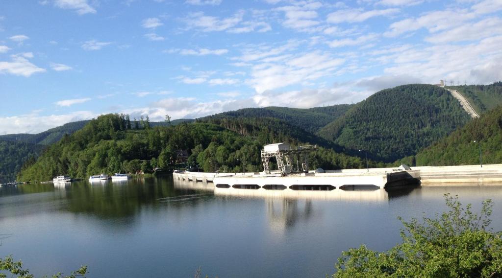 a large body of water with mountains in the background at Zur Sommerfrische Lothramühle in Drognitz