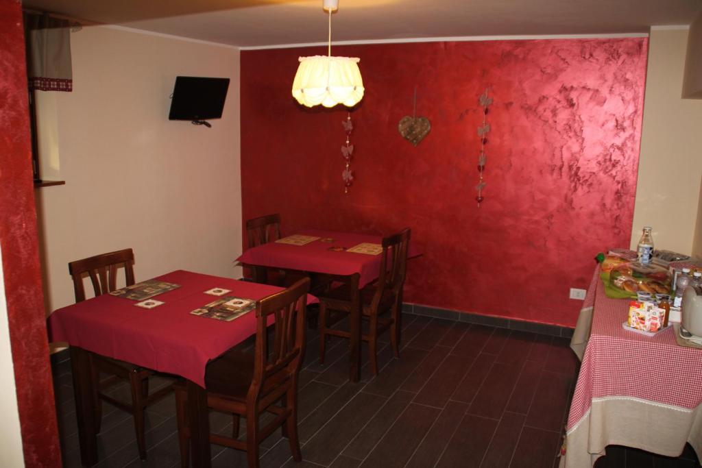 フランカヴィッラ・アル・マーレにあるUn Posto Al Soleの赤い壁のレストランのテーブル2台