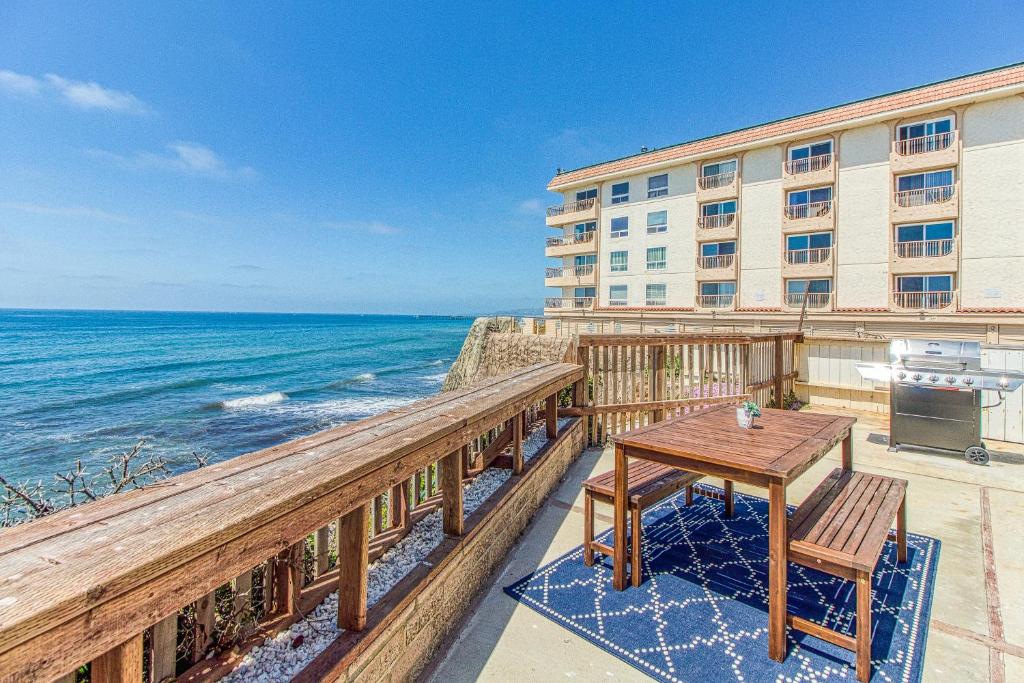 a balcony with a table and a view of the ocean at Ocean Beach Cliffs Sanctuary Oceanfront cottage w/unobstructed views & deck: steps to the water in San Diego