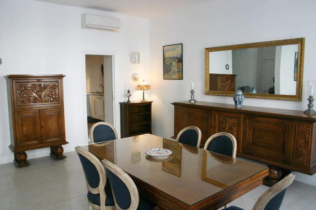 - une salle à manger avec une table, des chaises et un miroir dans l'établissement Nice centre- Superbe 100m2 - 10 mn à pied de la mer !, à Nice