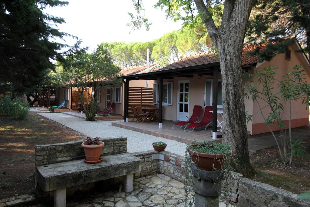 a small house with a bench in front of it at Bungalov comfort - 100 m from the beach in Premantura