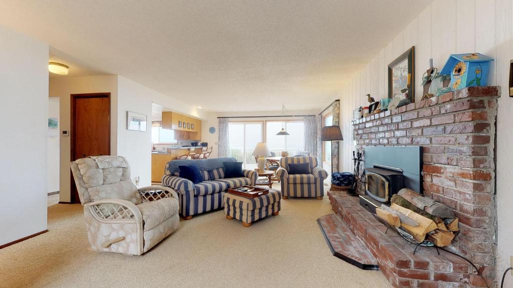 a living room with a brick fireplace and chairs at 2 Bed 2 Bath Vacation home in Waldport in Waldport