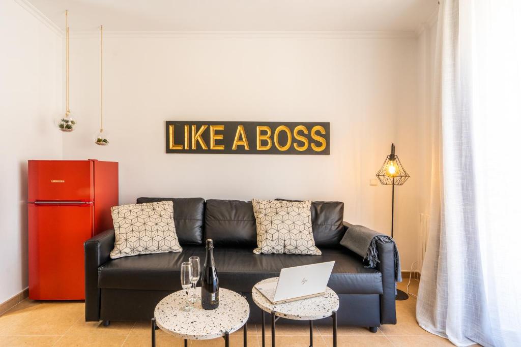 sala de estar con sofá negro y ordenador portátil en Trendy Homes Almería, en Almería