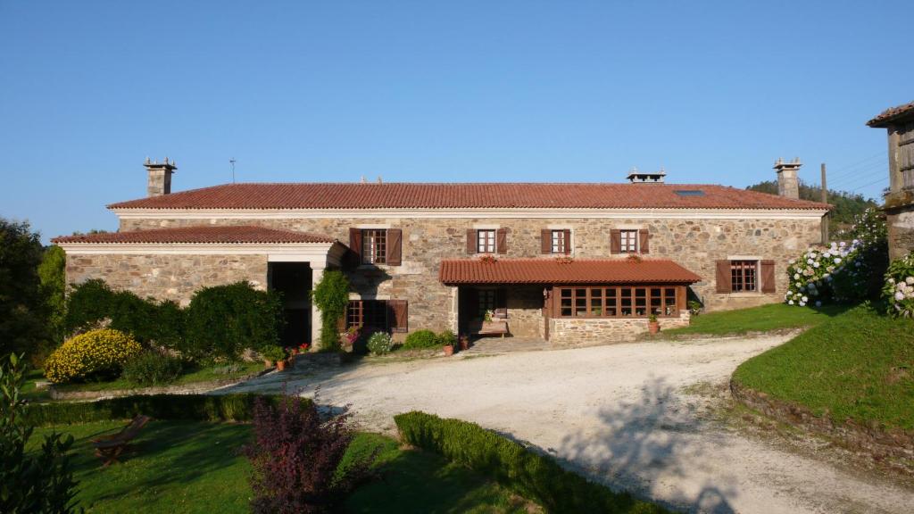 een groot stenen huis met een oprit bij Casa San Ginés in Cruces