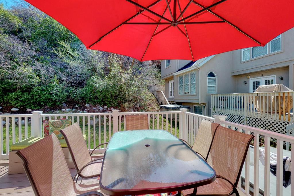a table and chairs with a red umbrella on a deck at 4 Bed 4 Bath Vacation home in Oaks at Wasatch in Cottonwood Heights