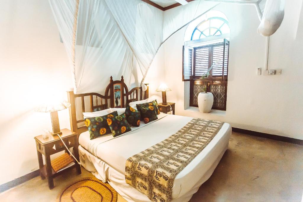 una camera da letto con un letto e una finestra di The Swahili House a Zanzibar City