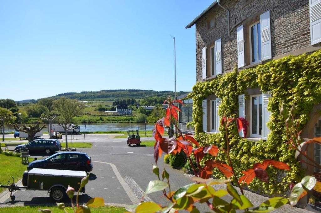 a building covered in ivy next to a parking lot at Weingut Erbes-Henn in Ürzig