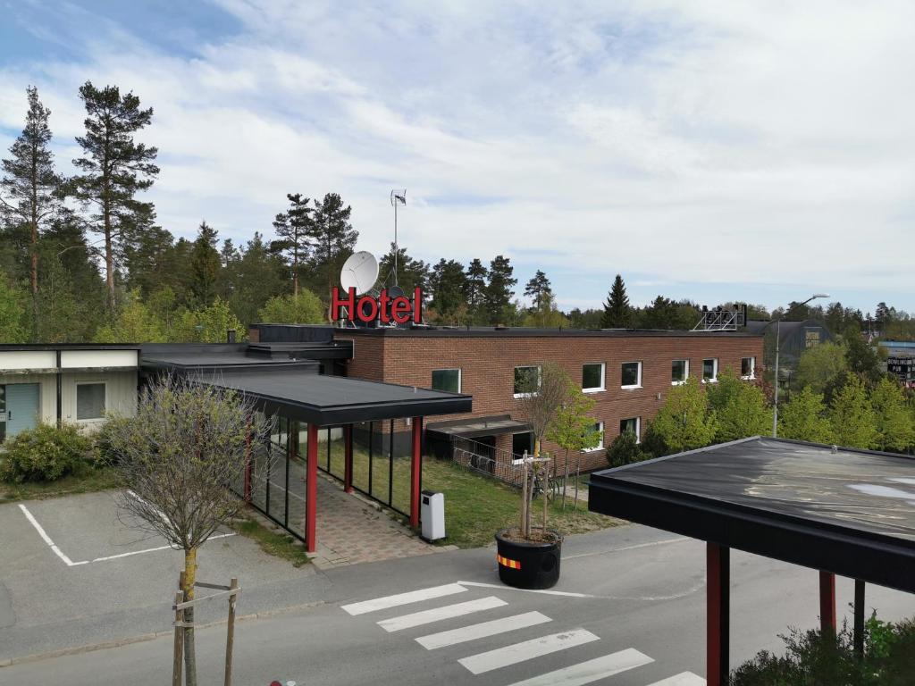 RastPunkt Laxå في Laxå: علامة موتيل على رأس مبنى مع موقف للسيارات