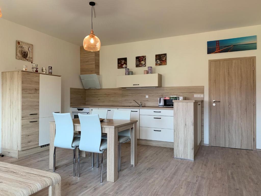 eine Küche mit einem Tisch und einigen blauen Stühlen in der Unterkunft Apartmán Monny in Frymburk