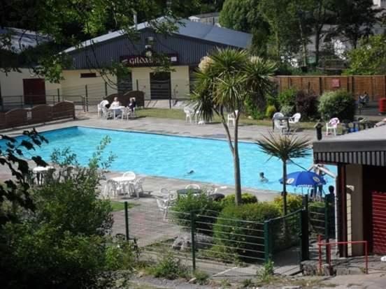 a large swimming pool with people swimming in it at Glangwna Holiday Park in Caernarfon