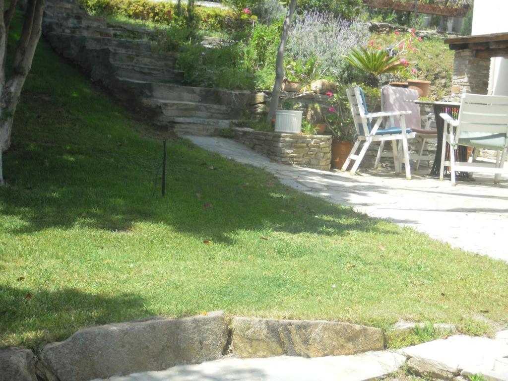 a yard with chairs and a table in the grass at Blue Dolphin in Batsi