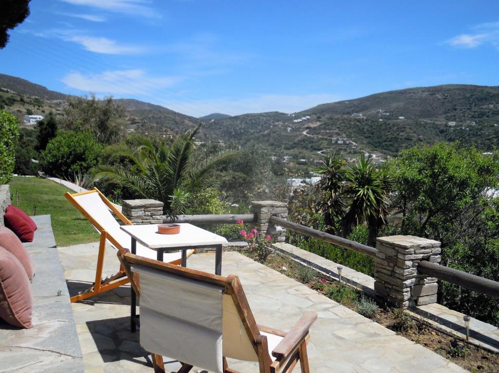 a patio with a table and chairs and mountains at Blue Dolphin in Batsi