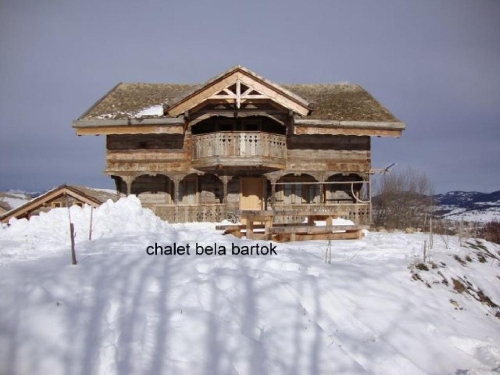 a large log cabin in the snow with a balcony at Ker Bela in Saint-Pierre-dels-Forcats