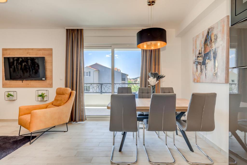 una sala da pranzo con tavolo e sedie di Magnolia 4* luxury apartment in town center a Trogir