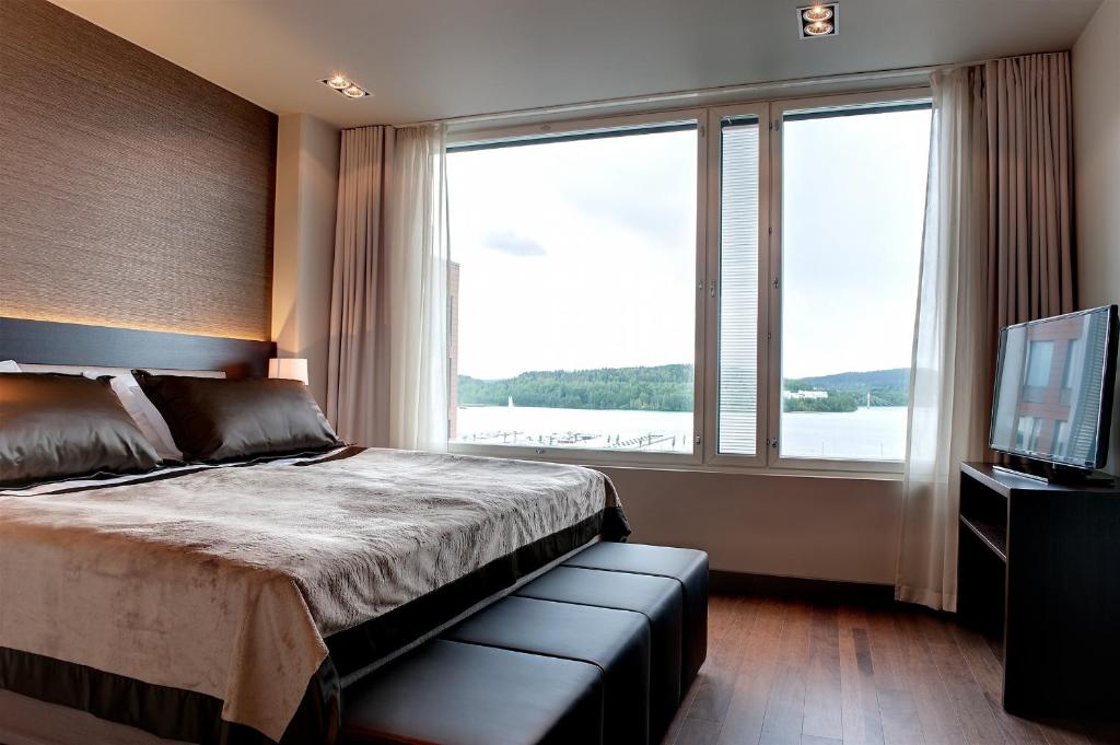 a bedroom with a bed and a large window at Solo Sokos Hotel Paviljonki in Jyväskylä