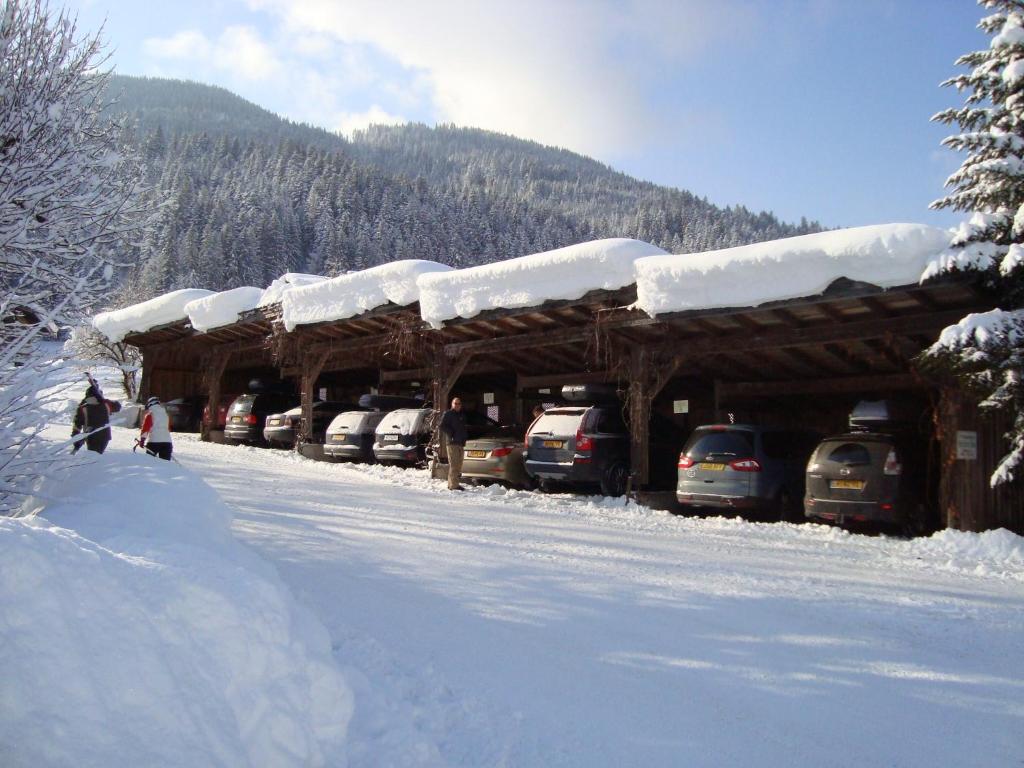 a snow covered building with cars parked in the snow at Appartements Schedererhaus in Going