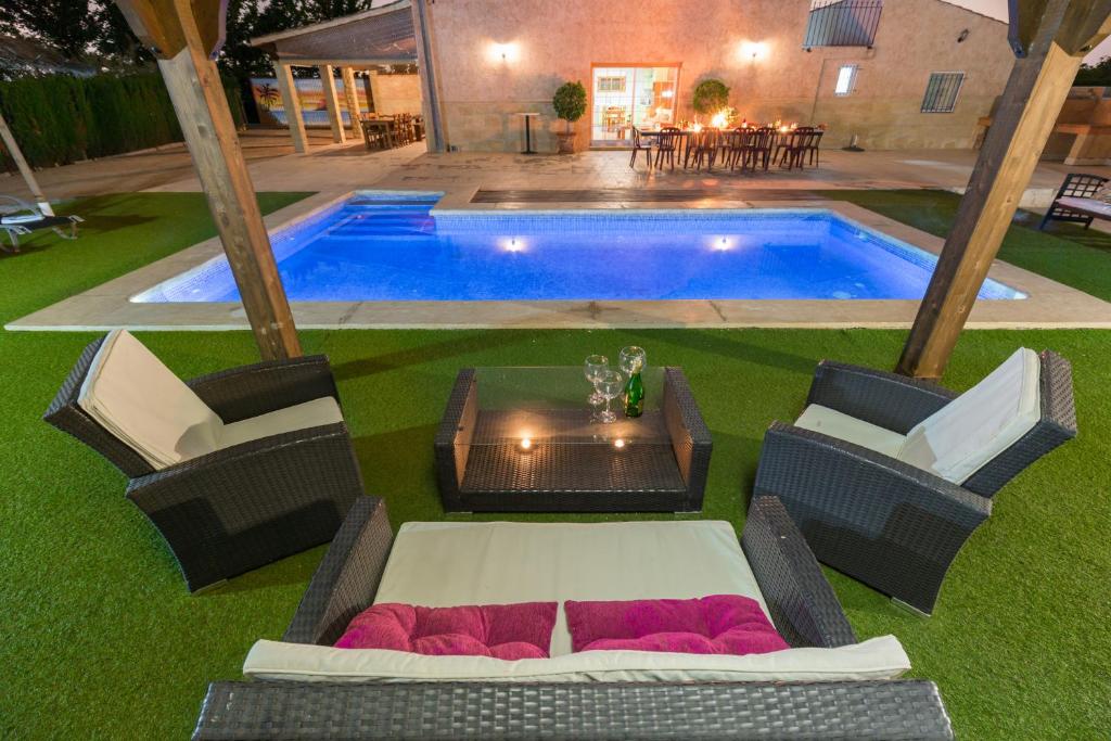 een uitzicht over een zwembad met stoelen en een tafel bij Fidalsa Sunny Valley in Catral