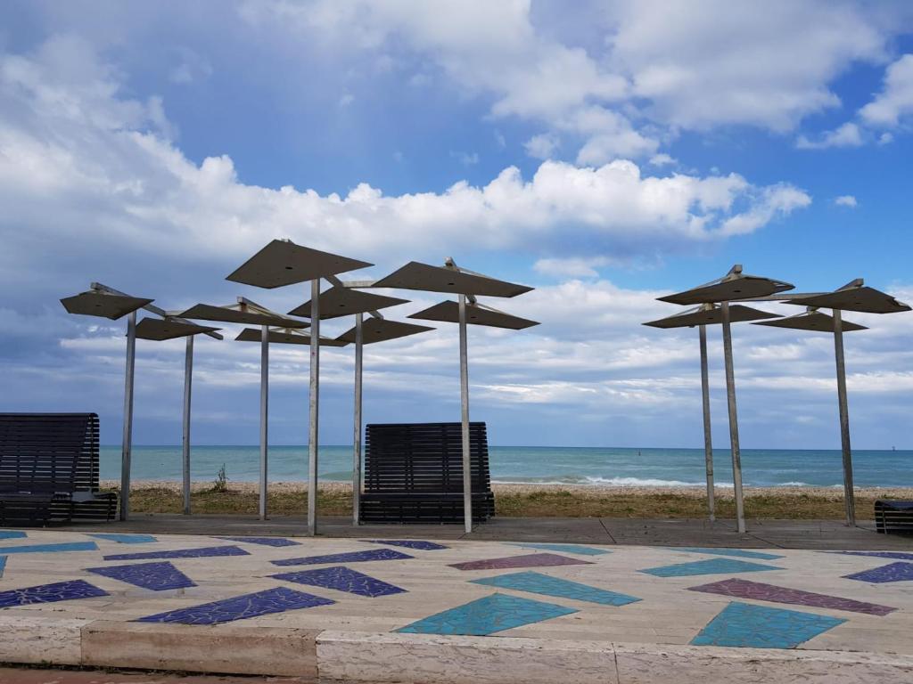 a group of umbrellas and chairs at the beach at Residenza Leonardo in Porto SantʼElpidio