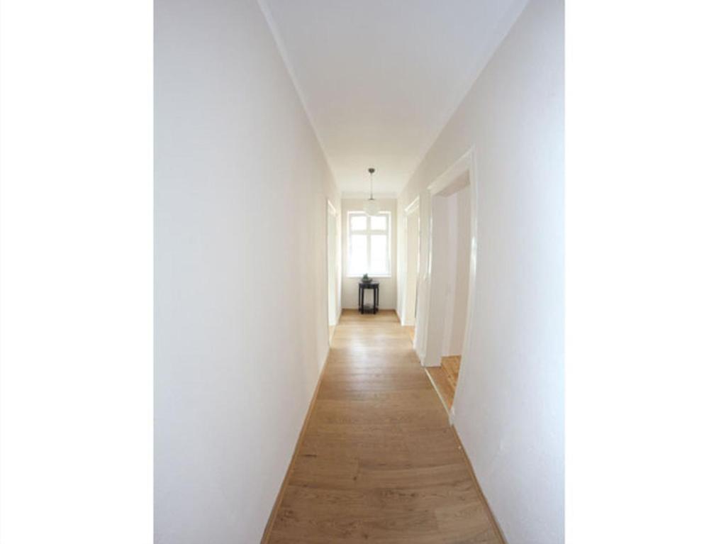 a hallway with white walls and a wooden floor at Posthof Kerstenhausen in Borken