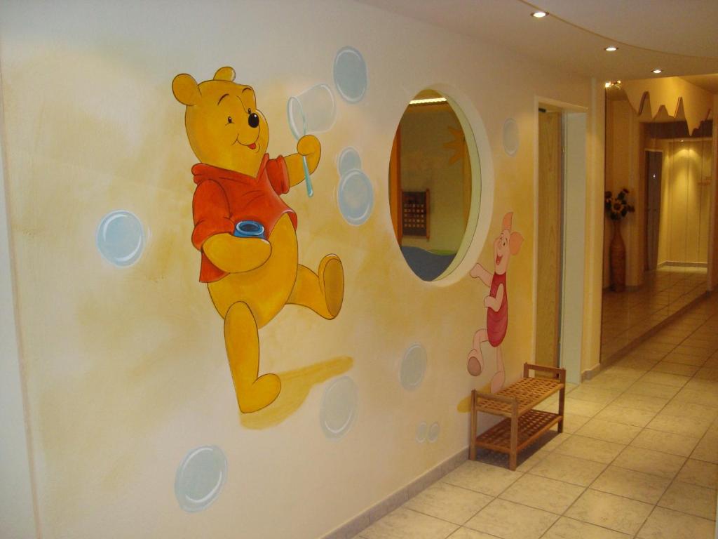 a teddy bear mural on a wall in a room at Appartements Schedererhaus in Going