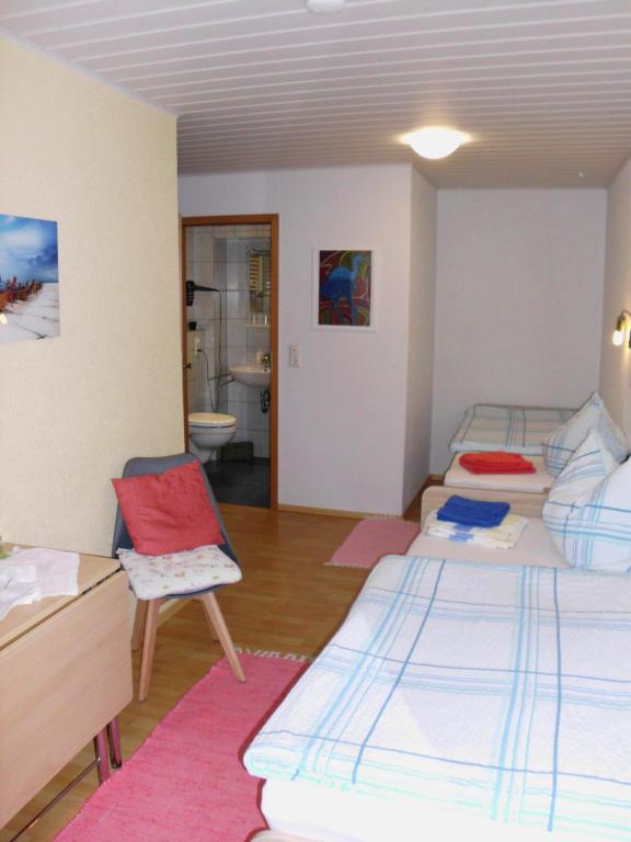 ツェル・アン・デル・モーゼルにあるGästezimmer Hoffmannのベッド3台とバスルームが備わる客室です。