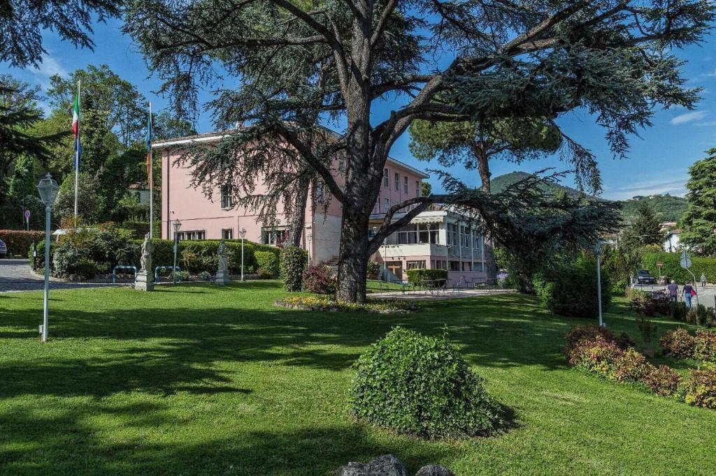 drzewo w środku parku z budynkiem w obiekcie Hotel Beatrice w mieście Este
