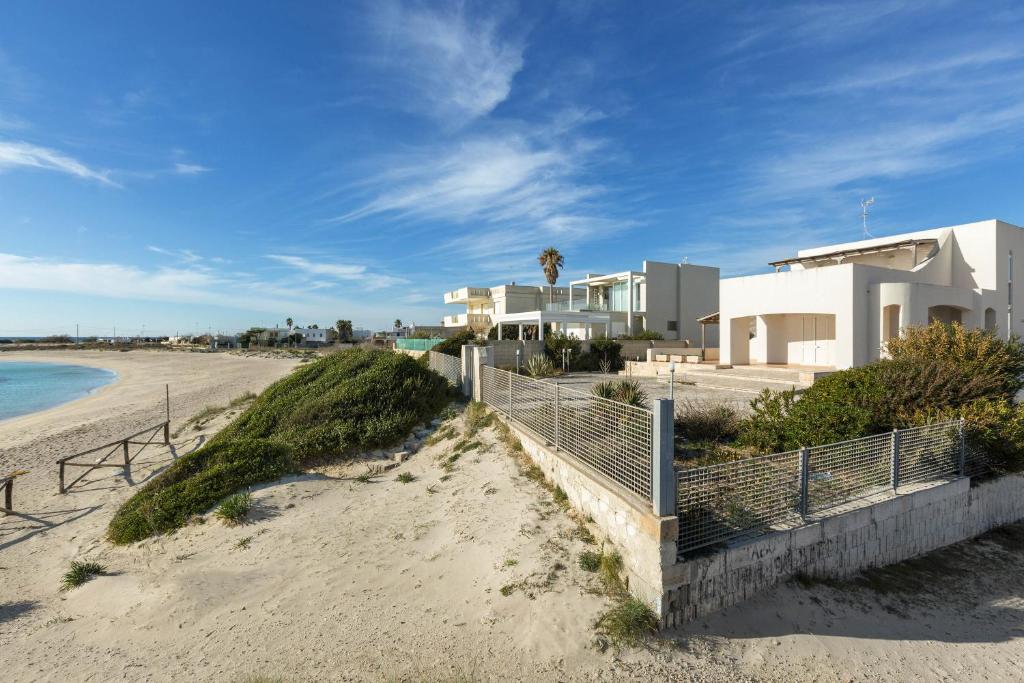 vista su una spiaggia con case e recinzione di Residence Tabù a Porto Cesareo