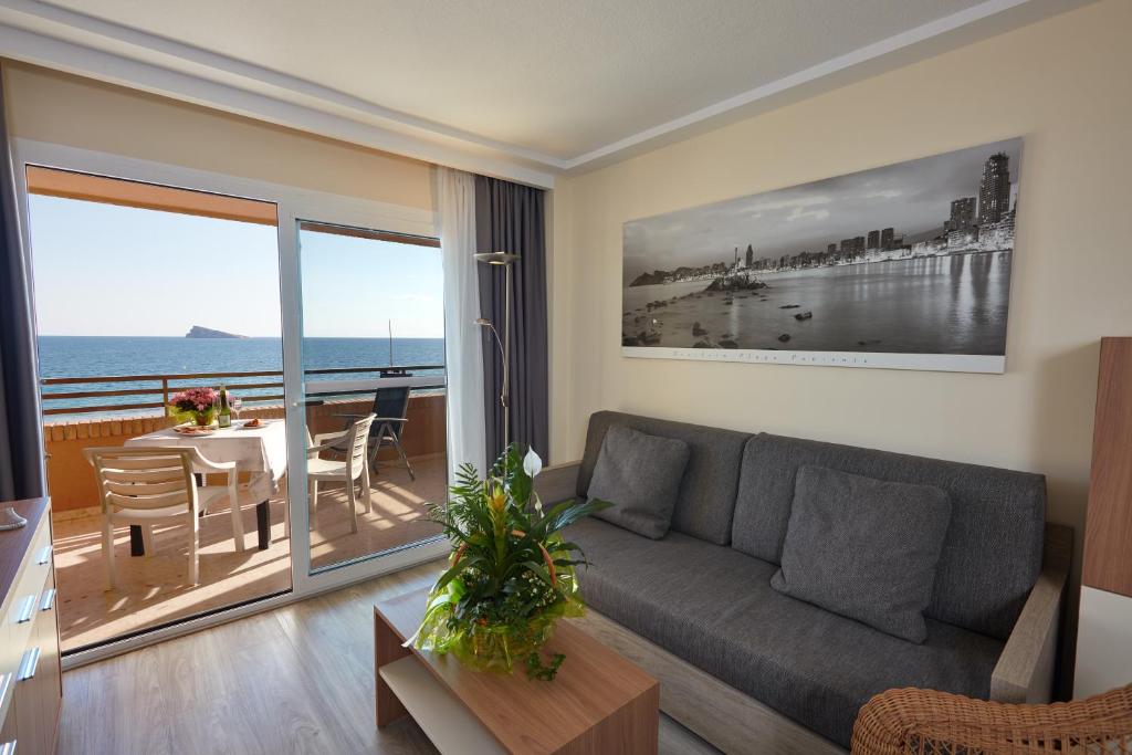 a living room with a couch and a table at Les Dunes Suites in Benidorm
