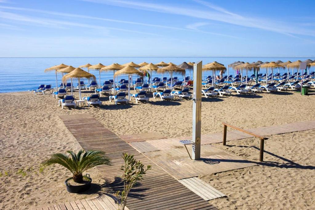 マルベーリャにあるBanana Beach 1a Li­nea de playaの海の景色を望むビーチ(椅子、パラソル付)