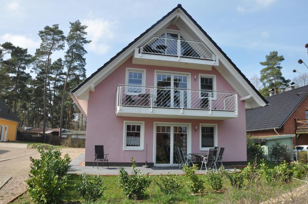 une maison rose avec un toit en gambrel dans l'établissement Ferienhaus Müritzzauber / 1 Zimmer Dachgeschoss-Appartement, à Röbel