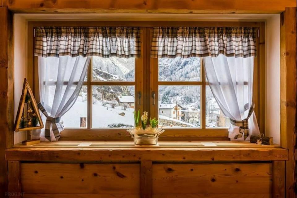 ein Fenster mit Blick auf einen schneebedeckten Berg in der Unterkunft I Riviù in Branzi
