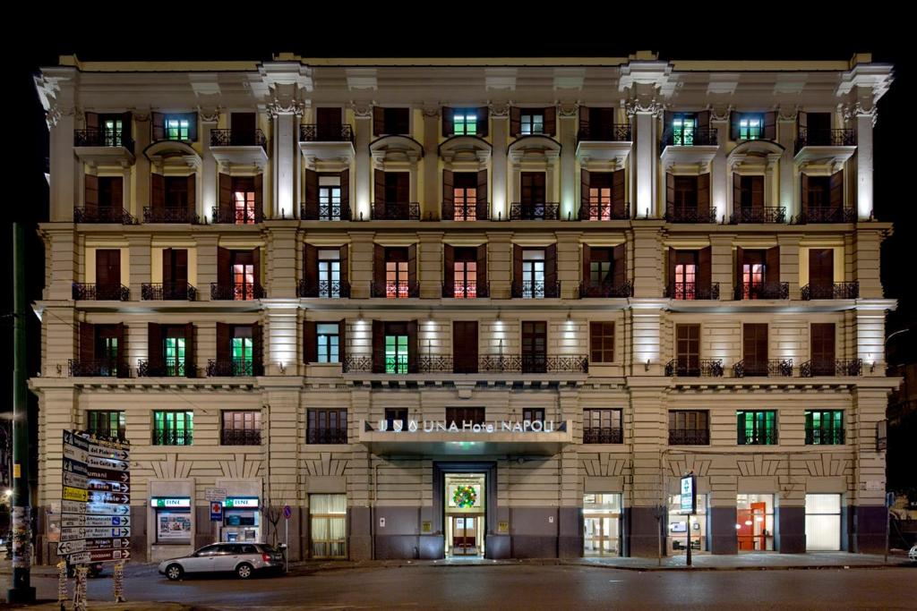 un edificio con un'auto parcheggiata di fronte di UNAHOTELS Napoli a Napoli