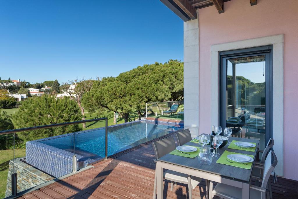 a dining table on the balcony of a house at Alexandra in Vale do Lobo
