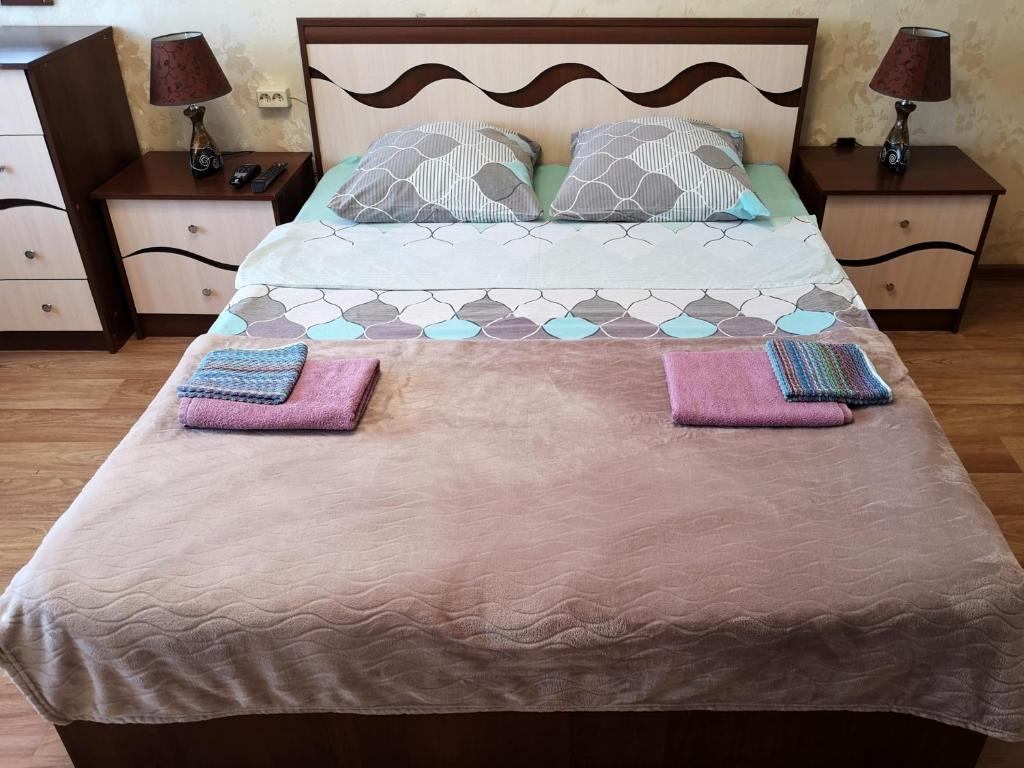 a large bed with two pillows and two towels on it at Квартира в центре Саранска in Saransk