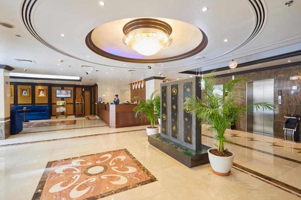 a lobby with a reception desk and plants in it at Dream City Hotel Apartments in Dubai