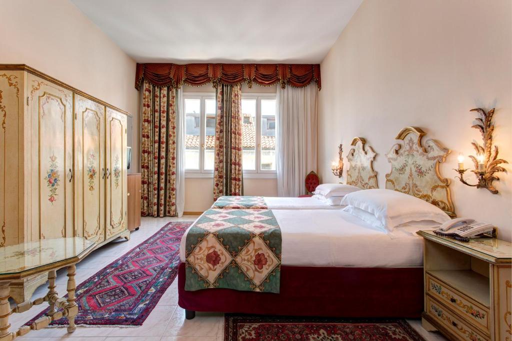 a bedroom with a large bed and a window at Hotel Biasutti in Venice-Lido