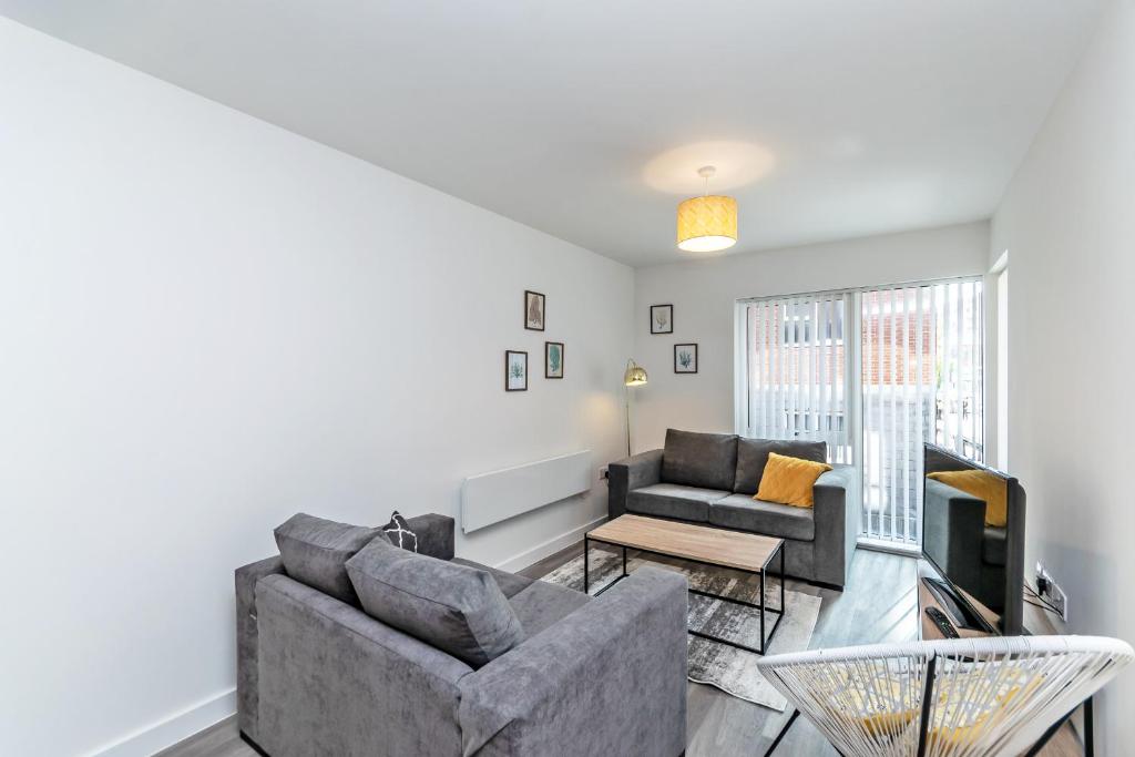 a living room with a couch and a tv at Halo House Apartments in Manchester