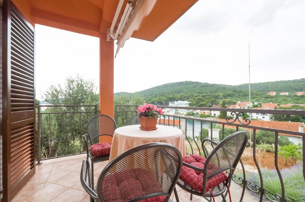 a table and chairs on a balcony with a view at Apartment Ante - sea view & serenity in Božava