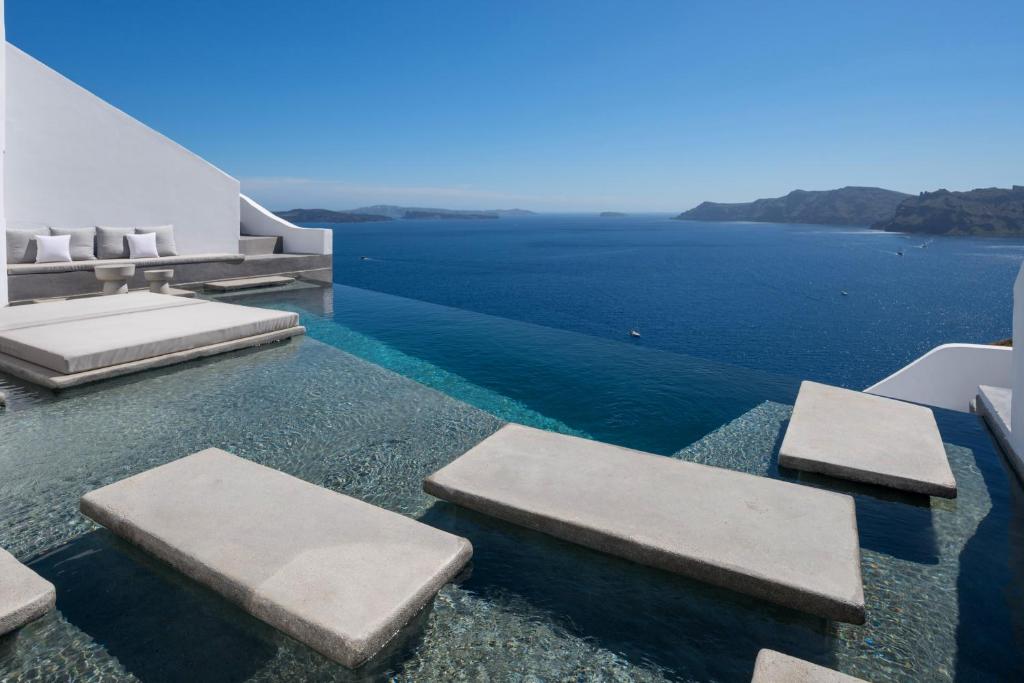 a swimming pool with a view of the ocean at Echoes Luxury Suites in Oia
