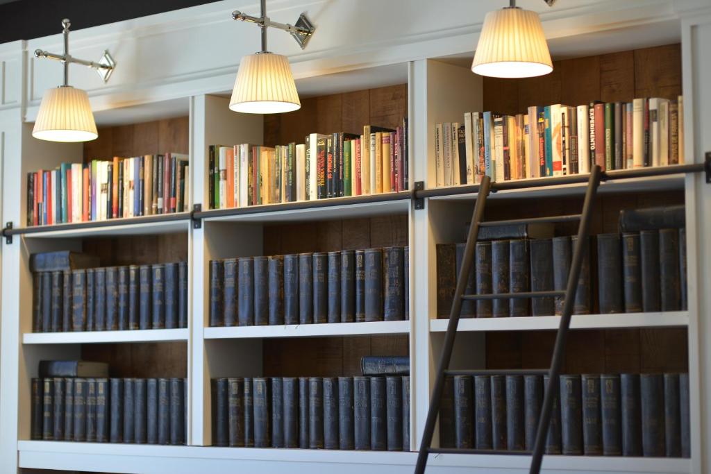 a library with white shelves filled with books at Hotel Granvia in Barcelona
