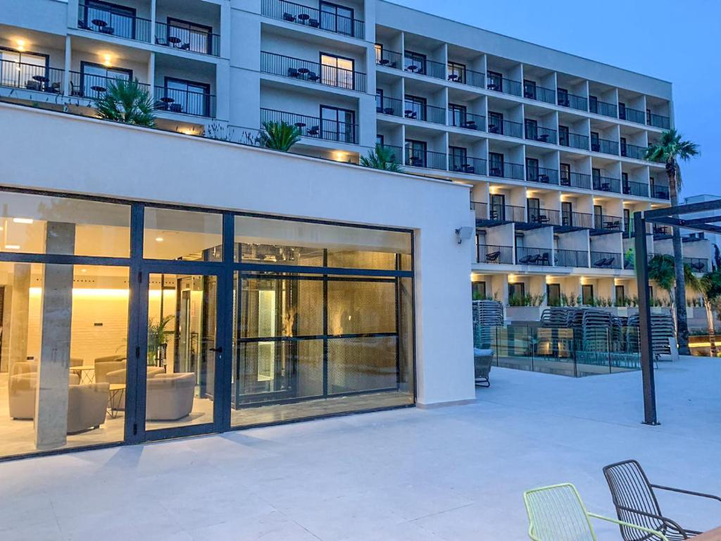 a building with glass doors and chairs in front of it at Hotel Paradiso Garden in Playa de Palma