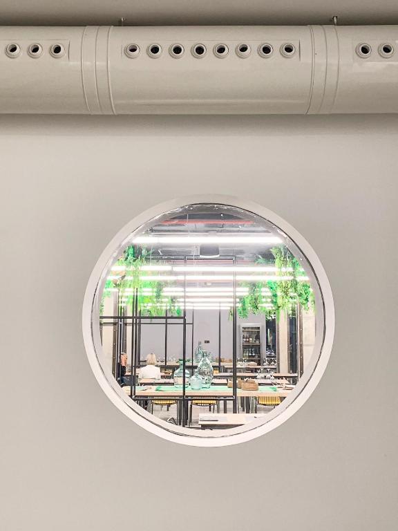 a round mirror hanging on a white wall at Hotel Paradiso Garden in Playa de Palma