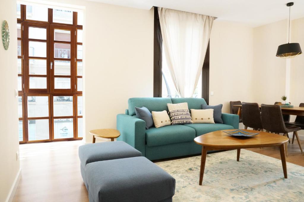 sala de estar con sofá azul y mesa en APARTAMENTOS RELOJ DE BERGERÓN, en Logroño