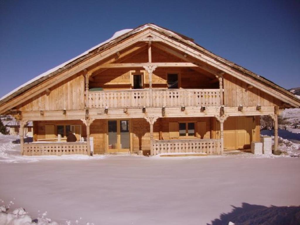 uma grande casa de madeira com neve no chão em Ker Carlit em Saint-Pierre-dels-Forcats