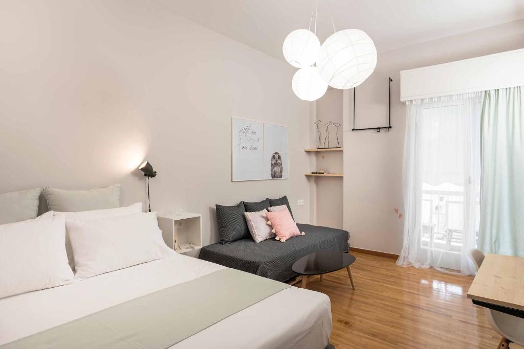 - une chambre blanche avec un lit et un canapé dans l'établissement The CucuWow, à Athènes