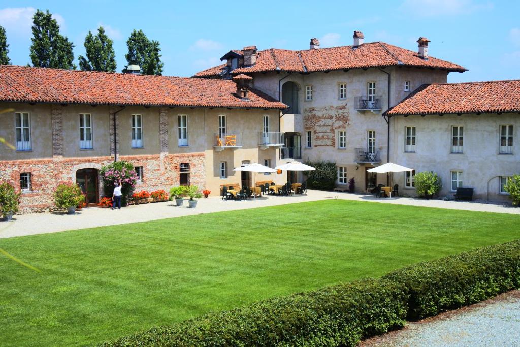 a large building with a lawn in front of it at Hotel Antico Podere Propano in Saluzzo