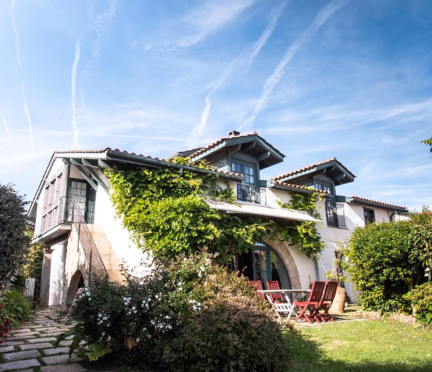 an exterior view of a white house with chairs at Casaviel in Biarritz