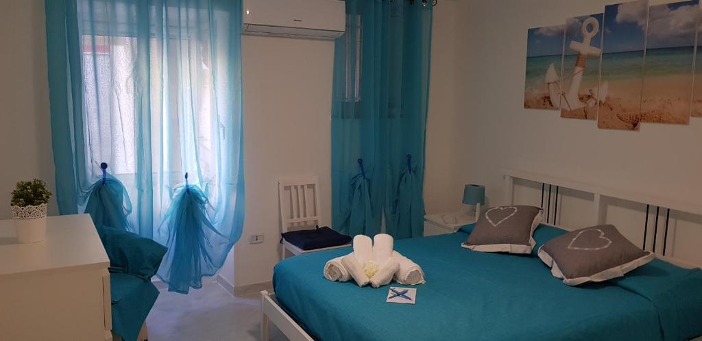 sypialnia z 2 łóżkami pojedynczymi i niebieskimi zasłonami w obiekcie Petra Marina Home w mieście Pisciotta