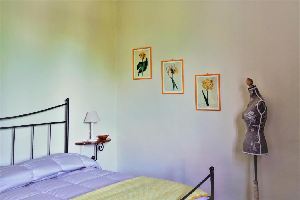 a bedroom with a bed and three pictures on the wall at La Quercia di Aorivola in Caianello Vecchio
